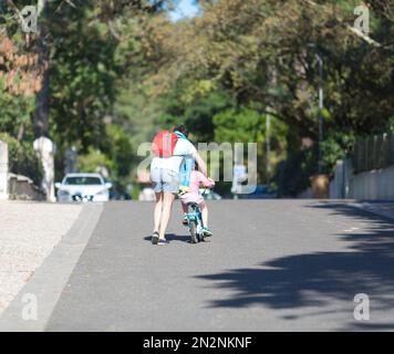 Glücklicher Familienvater lehrt Tochter Fahrrad zu fahren Stockfoto