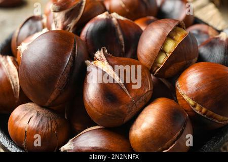 Leckere geröstete essbare Kastanien in der Bratpfanne, Nahaufnahme Stockfoto