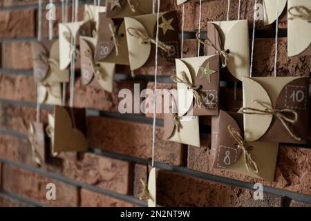 Der Weihnachtskalender hängt drinnen an einer Backsteinwand Stockfoto