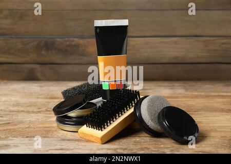 Komposition mit Schuhpflegezubehör auf Holztisch Stockfoto