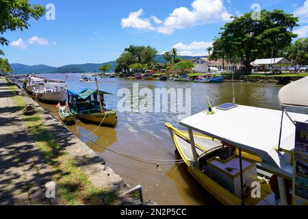 PARATY, BRASILIEN - 25. DEZEMBER 2022: Uferpromenade mit traditionellen bunten Booten des historischen Zentrums von Paraty, Rio de Janeiro, Brasilien Stockfoto