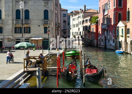 Rio dei Mendicanti Kanal mit Gondolieren, die auf Touristen in Campo Santi Giovanni und Paolo Platz im Sommer warten, Venedig, Veneto, Italien Stockfoto