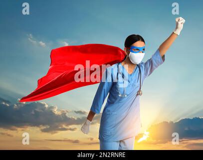 Medizinische Arbeiter, die mit gefährlichen Krankheiten kämpfen. Ein Arzt, der sich als Superheld verkleidet und gegen den Himmel posiert Stockfoto