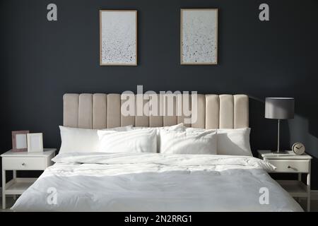 Komfortables Bett mit weicher Decke und stilvoller Innenausstattung Stockfoto