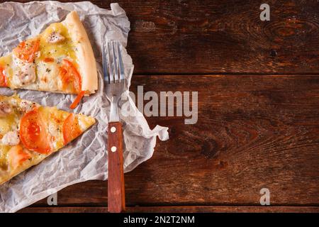 Köstliche Pizza auf einem rustikalen Holztisch Stockfoto