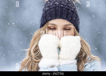 Mädchen in warmer Kleidung, die an einem eiskalten Wintertag aus der kalten Natur zittert. Stockfoto