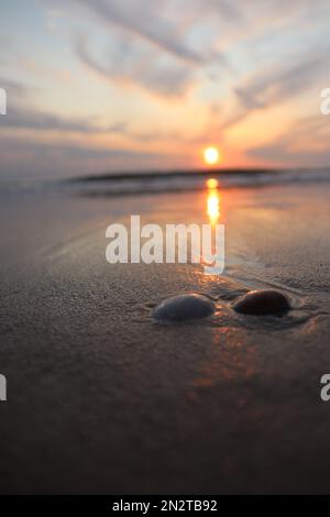 Eine vertikale Aufnahme eines faszinierenden, ruhigen Sonnenuntergangs über dem Meer Stockfoto