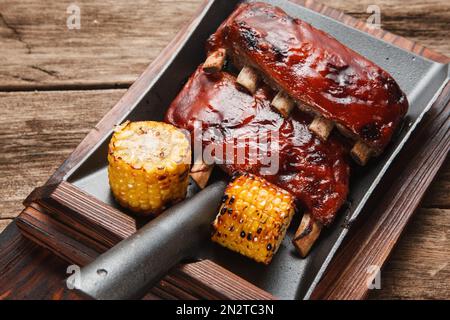Gegrillte Schweinerippchen serviert mit Mais. Fettes Junkfood. Stockfoto