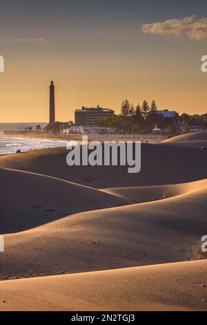 Blick auf den Leuchtturm von Maspalomas von den Dünen bei Sonnenuntergang, Gran Canaria, Kanarische Inseln, Spanien Stockfoto