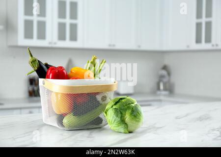 Verschiedene frische Gemüsesorten im Korb auf weißem Küchentisch. Platz für Text Stockfoto