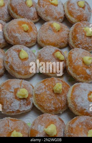 Hausgemachte gebratene Donuts gefüllt mit Vanille und gewürzt mit einem Schleier Zucker Stockfoto