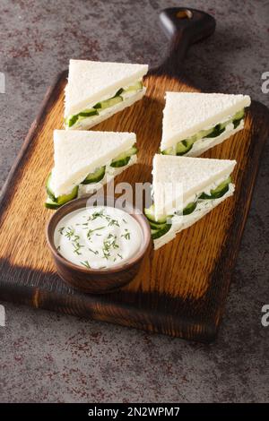 Gurkensandwich ist ein krustfreies Teesandwich, das aus dünnen Gurkenscheiben besteht, die sich zwischen zwei dünnen Scheiben von leicht buttertem Weißbrot befinden Stockfoto