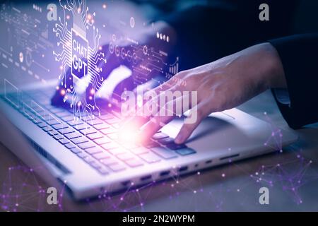 ChatGPT-Chats mit künstlicher Intelligenz oder KI. Geschäftsmann, der Notebook (Laptop) mit Chatbot von OpenAI verwendet. Futuristisches Technologiekonzept. Stockfoto