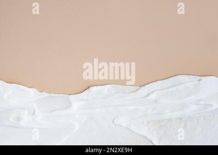 Weiße cremefarbene Abstriche auf beigem Hintergrund, cremefarbene Konsistenz Stockfoto