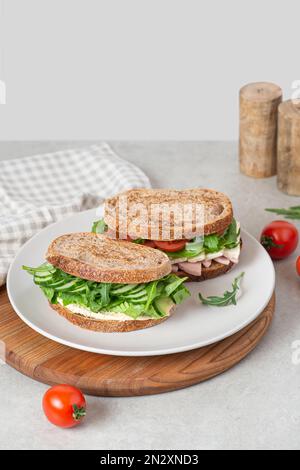 Sandwiches mit verschiedenen Füllungen auf einem Teller auf dem Tisch Stockfoto