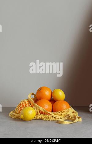 Keine Verpackungsabfälle. Orangen und Zitronen in einer Schnur auf dem Tisch Stockfoto