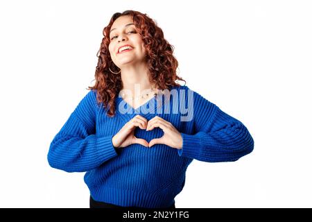 Süße Millennials Frau, die isoliert über weißem Hintergrund steht und eine Geste des Herzens für Liebe und Pflege Beziehung, Wohltätigkeit, Herz-Kreislauf-Erkrankungen zeigt. Stockfoto