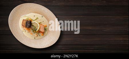 Gegrilltes Lachssteak mit Gemüse, Sauce und Zitrone auf Holzhintergrund. Banner Stockfoto
