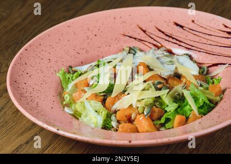 Gerichte vom Küchenchef des Restaurants. Ein Gericht auf einem Tisch in einem Café. Leckeres Essen von der Speisekarte des Restaurants. Frisches und leckeres Essen. Kürbissalat-Witz Stockfoto