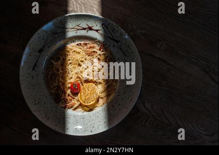 Gerichte vom Küchenchef des Restaurants. Ein Gericht auf einem Tisch in einem Café. Leckeres Essen von der Speisekarte des Restaurants. Frisches und leckeres Essen. Carbonara in einem Pl Stockfoto