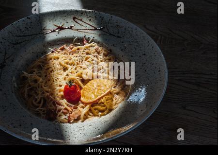 Gerichte vom Küchenchef des Restaurants. Ein Gericht auf einem Tisch in einem Café. Leckeres Essen von der Speisekarte des Restaurants. Frisches und leckeres Essen. Carbonara in einem Pl Stockfoto