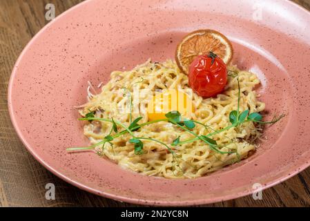 Gerichte vom Küchenchef des Restaurants. Ein Gericht auf einem Tisch in einem Café. Leckeres Essen von der Speisekarte des Restaurants. Frisches und leckeres Essen. Carbonara Sprinkl Stockfoto