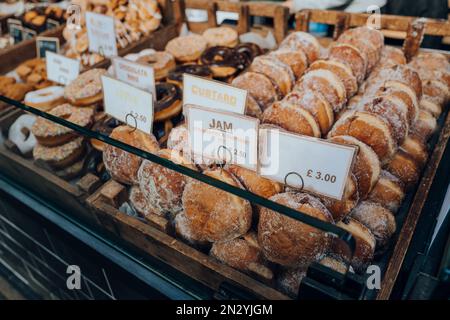 Nahaufnahme einer Vielzahl von Donuts bei einem Verkauf auf einem Markt in London, Großbritannien. Selektiver Fokus. Stockfoto