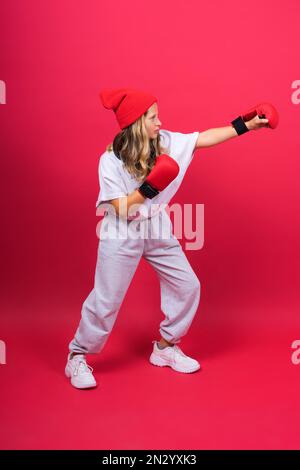 Ein kleines Mädchen mit roten Boxhandschuhen, Studioaufnahme, Sportsgeist Stockfoto