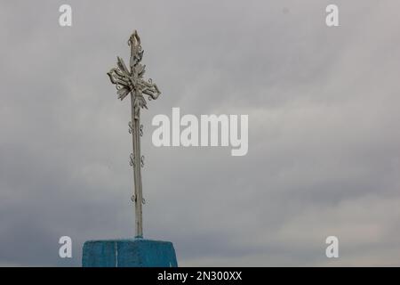 Altes Metallkreuz auf dem Hintergrund des Himmels Stockfoto