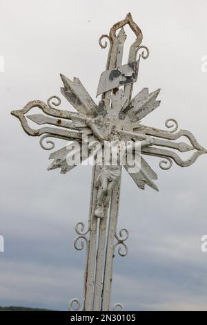 Altes Metallkreuz auf dem Hintergrund des Himmels Stockfoto