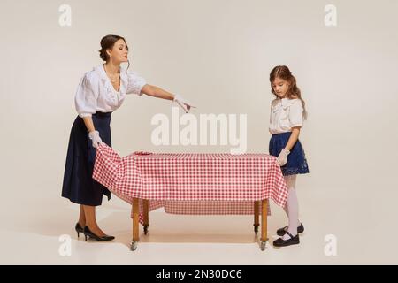 Porträt von jungen Frauen und kleinen Mädchen, Mutter und Tochter Tischset isoliert vor hellem Hintergrund. Konzept von Schönheit, Retro-Stil, Mode Stockfoto