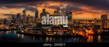 Canary Wharf und die Skyline von London in der Abenddämmerung mit untergehender Sonne und Straßenbeleuchtung mit Blick auf das Finanz- und Geschäftsviertel. Bankwesen in England Stockfoto