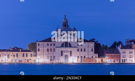 Venedig, Italien, bei Nacht beleuchtet mit glühenden Kanälen, historischer Architektur, Brücken und Reflexionen auf dem Wasser. Stockfoto