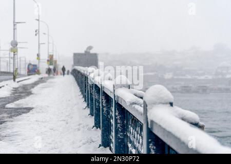 Schneebedeckte Galata-Brücke an einem Wintertag in Istanbul, Türkei. Stockfoto