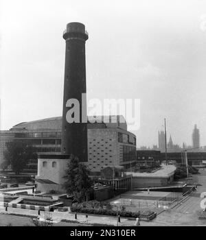 1950er, historisch, Außenansicht des Shot Tower und der Royal Festival Hall, auf der South Bank, Lambeth, London, England, Großbritannien. Der Schießturm bei den Lambeth Blei Werken wurde 1826 erbaut und war das einzige bestehende Gebäude auf dem Gelände des britischen Festivals im Jahr 1951. Die von Sir Robert Matthew und J L Martin entworfene Halle wurde 1949-51 als Konzerthalle für das Festival erbaut. Die Waterloo Bridge ist in der Ferne. 1962 wurde der Turm abgerissen und die Queen Elizabeth Hall wurde 1967 eröffnet. Stockfoto