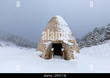 Schneegruben in Sierra Espuna, Region Murcia, Spanien, in einer verschneiten Landschaft. Es handelt sich um mittelalterliche Bauwerke aus Ziegelsteinen, die zur Lagerung von Eis verwendet wurden Stockfoto