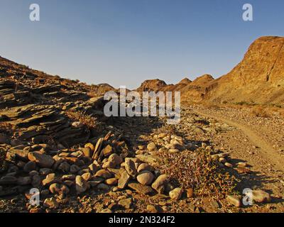 Ein Wanderweg durch die karge, felsige Landschaft am Ende des Fish River Canyon Hiking Trail in Namibia Stockfoto