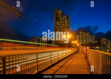 Ein Blick aus der Vogelperspektive auf leichte Wege auf der Straße, die von Gebäuden in Hongkong umgeben sind Stockfoto