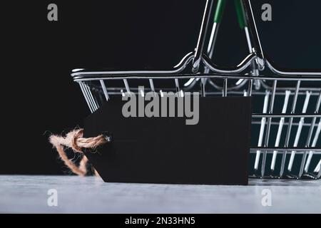 Warenkorb und leeres Preisschild für die Beschriftung. Der Preis des Produkts. Verkauf im Supermarkt. Stockfoto