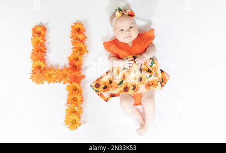 Süßes, 4 Monate altes Mädchen in einem Kleid. 4 Monate altes Baby Stockfoto