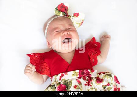 Weinendes weißes Mädchen in einem roten Kleid. Weinendes Kind. Stockfoto
