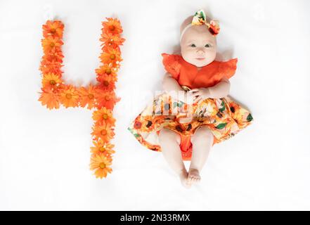 Süßes, 4 Monate altes Mädchen in einem Kleid. 4 Monate altes Baby Stockfoto