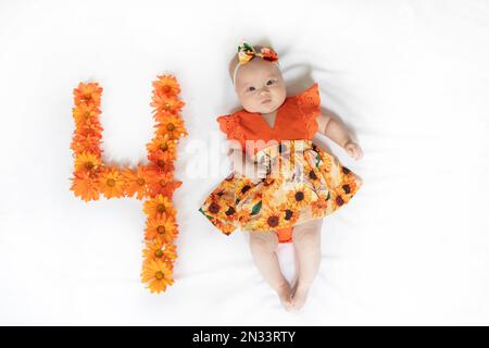 Süßes, 4 Monate altes Mädchen in einem Kleid. 4 Monate altes Baby Stockfoto