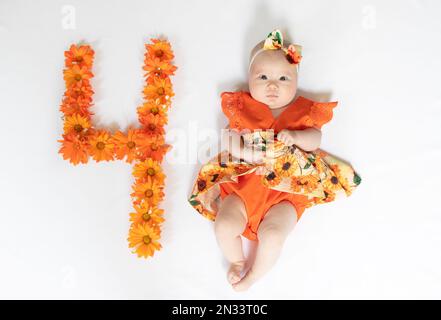 Süßes, 4 Monate altes Mädchen in einem Kleid. 4 Monate altes Baby Stockfoto