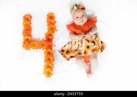 Süßes, 4 Monate altes Mädchen in einem Kleid. 4 Monate altes Baby Stockfoto