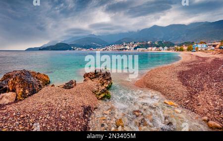 Düsterer Blick auf den öffentlichen Strand von Potam. Farbenfrohe morgendliche Meereslandschaft der Adria. Atemberaubendes Stadtbild von Himare, Albanien, Europa. Reisebetrug Stockfoto