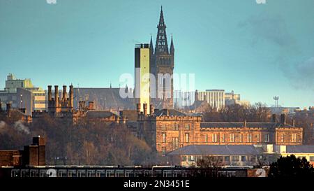 Glasgow, Schottland, Vereinigtes Königreich 7. Februar 2023. UK Weather: Die Temperaturen über Nacht waren eiskalt, und die Sonne nutzte die Pausen in der Wolke, um Spätsonne in städtischen Krankenhäusern zu erzeugen. Das alte Gebäude des Gartnavel Royal Hospital im West End ist eine psychiatrische Einrichtung, die vom gotischen Turm der Universität Glasgow in der komprimierten Distanz Credit Gerard Ferry/Alamy Live News in den Schatten gestellt wird Stockfoto