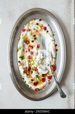 Griechisches Joghurtgericht mit Beeren, Nüssen und Grüne Minze. Stockfoto