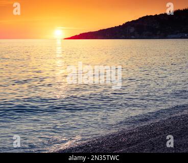 Spektakulärer Sonnenuntergang am Livadhi Strand, Lage in Himare. Farbenfroher Sommermorgen in Albanien, Europa. Aufregende Meereslandschaft der Adria mit endlosem Horiz Stockfoto