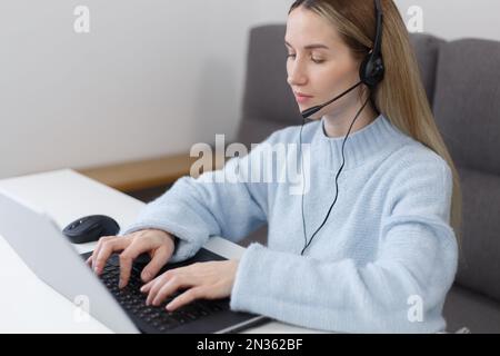 Der Online-Support-Assistent arbeitet zu Hause auf einem Laptop. Callcenter-Mitarbeiter, die mit modernen Notebooks arbeiten Stockfoto